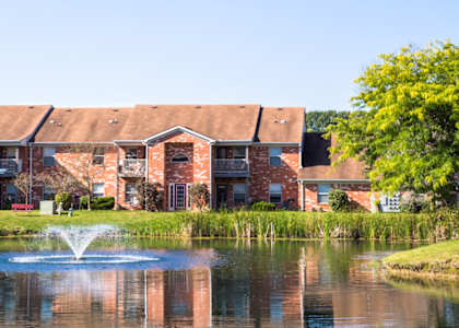 Lake view with fountain and trees at Bradford Run Apartments, 3604 Briarwick Dr, Kokomo