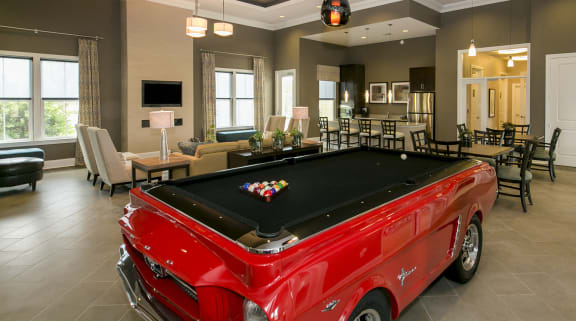 a pool table with a red truck in the middle of the room