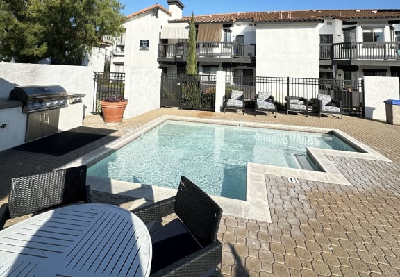 a resort style pool with a table and chairs around it at The Bryant Apartments at Yorba Linda, Yorba Linda California