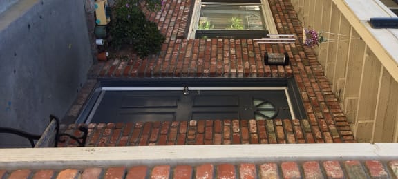 the front porch of a brick building with a black door