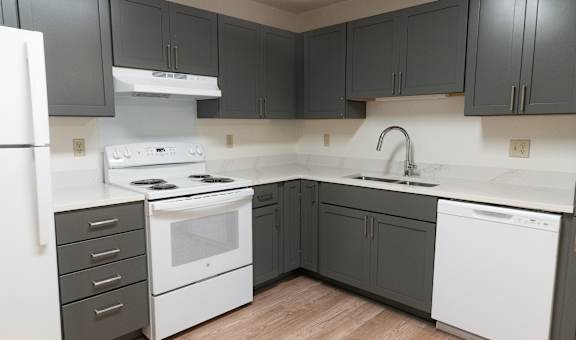 A kitchen with a white refrigerator, white oven, and white dishwasher.