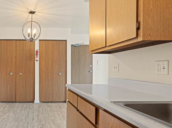 A kitchen with wooden cabinets and a white counter top.