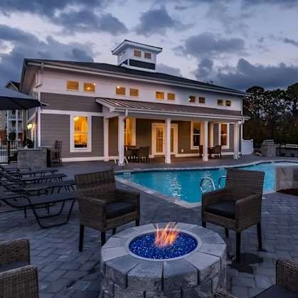 a backyard with a pool and patio with chairs and a fire pit at Westport Apartments, Norfolk