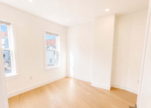 A room with wooden flooring and white walls.