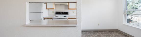 A kitchen with a fridge, stove, and oven is visible through a window.