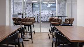A conference room with a glass divider and wooden tables.
