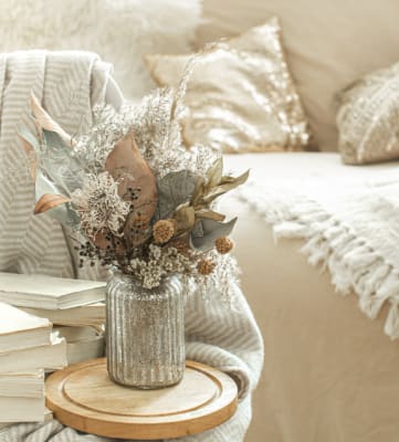 Ashbrooke Apartments Homepage Slider Image A Couch with a vase of flowers in front of it and some decorative books