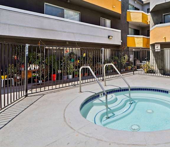 A small round pool with a fountain in the middle.