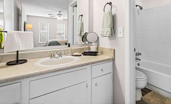A bathroom with a white sink and a white toilet.