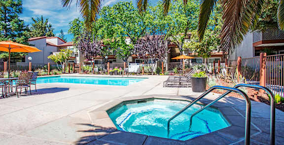 our apartments have a swimming pool and a patio with chairs and umbrellas at Valley Plaza Villages, Pleasanton, 94566