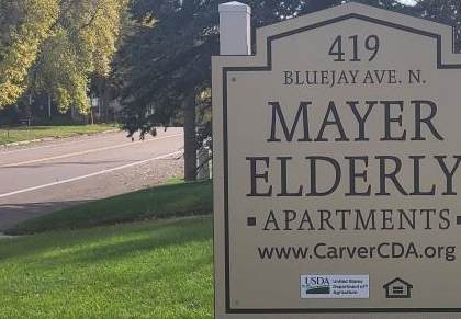 a sign in the grass in front of a cemetery
