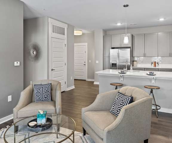 Living room looking into kitchen with chairs and breakfast bar seating at Central Island Square, Daniel Island, SC