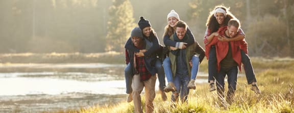 Friends Holding Each Other Walking Through Forest