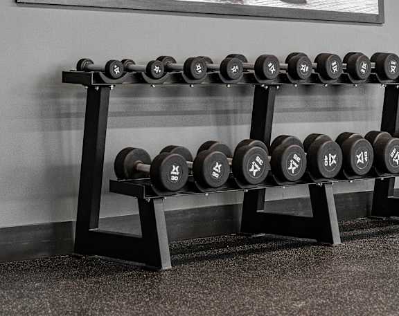Fitness center with dumbbells and motivational artwork at Mac and Mullen Apartments, Alberta
