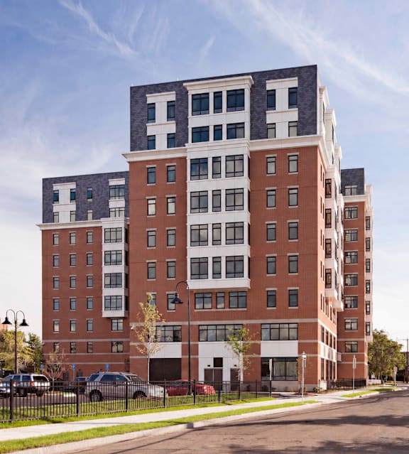A large red brick building with a white section on the top floor.