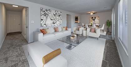 A living room with a white couch and a glass coffee table.