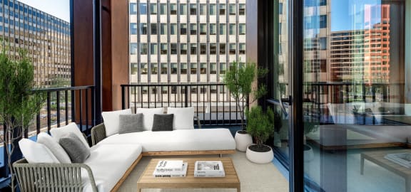 a living area with a couch and a table on a balcony