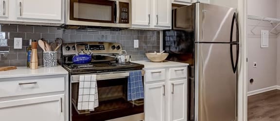a kitchen with white cabinets and stainless steel appliances