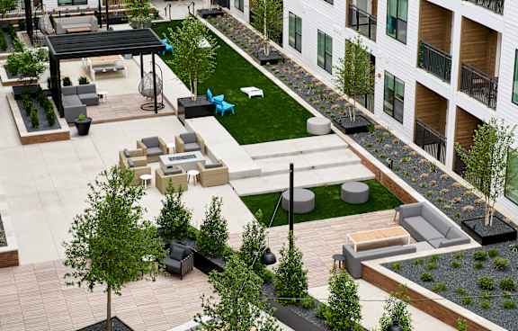 A large atrium with a green lawn and trees in the middle of a building.