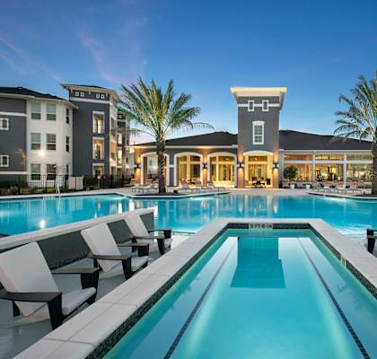 Pool surrounded by clubhouse and buildings at The Parkway on Westlake, Texas, 77346