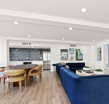 A modern living room with a blue sofa and wooden floors at Harvard Manor, Irvine California