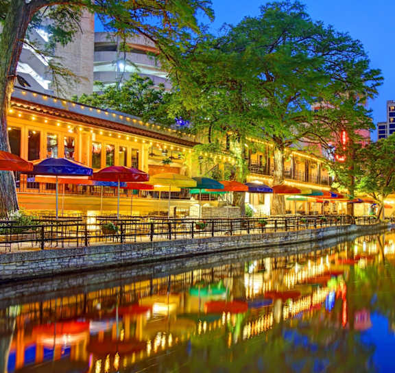 A beautiful night scene of a canal with lights reflecting on the water.