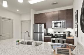 a kitchen with a sink a stove and a microwave