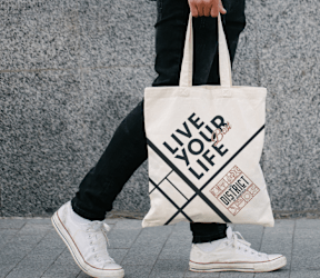 A person is carrying a tote bag with the words at The District at Deerfield Residences Apartments, Mason, OH, 45040