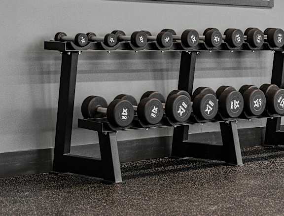 A person is lifting a kettlebell in a gym.