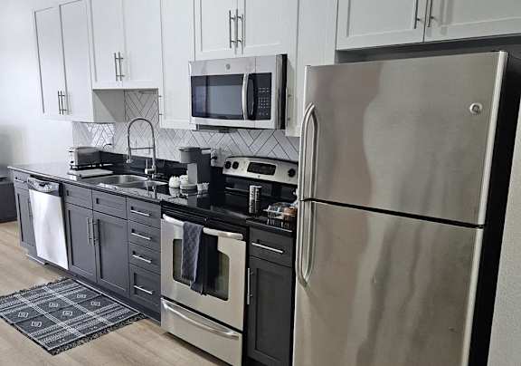 a kitchen with stainless steel appliances and white cabinets