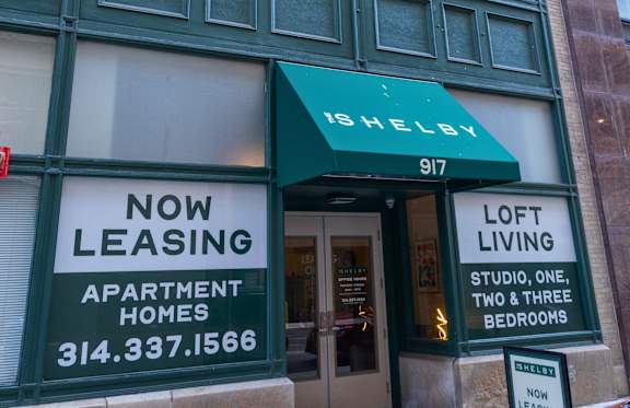 A building with a green awning and a sign that says "Shelby 917".