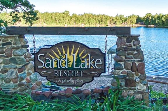 the sign for sandy lake resort at the entrance to the lake