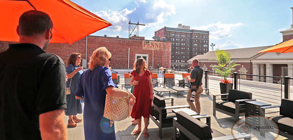 a group of people standing on a roof top patio