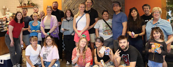 A group of people posing for a photo in a room with a wooden wall.