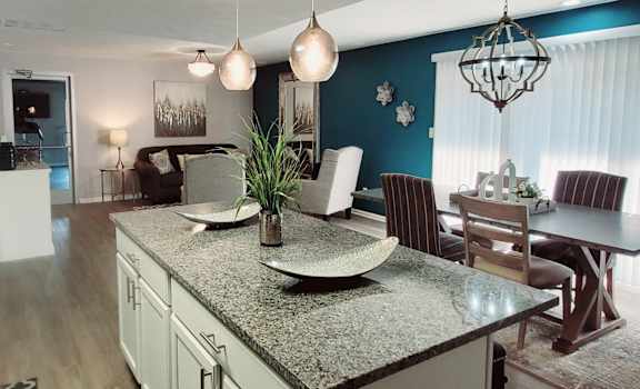 A kitchen with a table and chairs in the middle of the room.