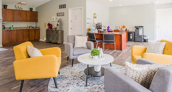 a living room with couches and chairs and a kitchen
