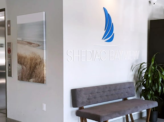 a lobby with a bench and a logo on the wall