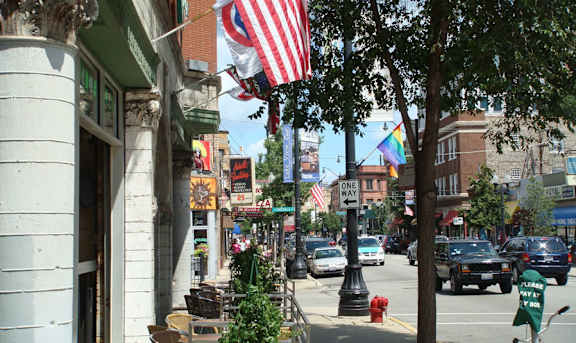 A street view with a rainbow flag and an American flag.
