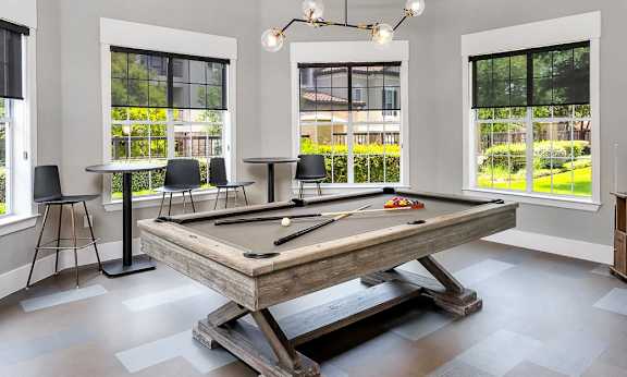 a pool table in a game room with colorful ceiling lights