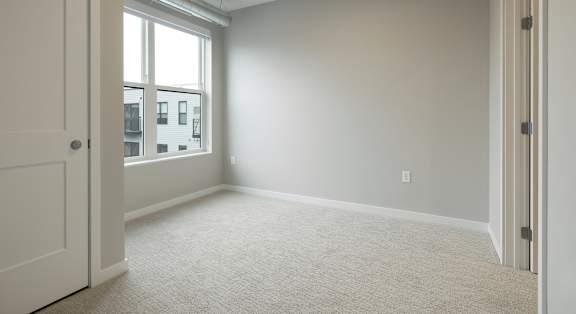 A room with a carpet floor and a window.