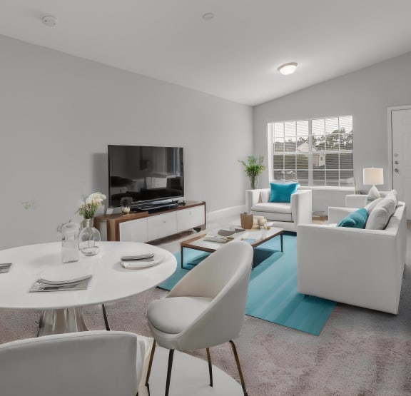 Living room with couch, tv and dining table with chairs