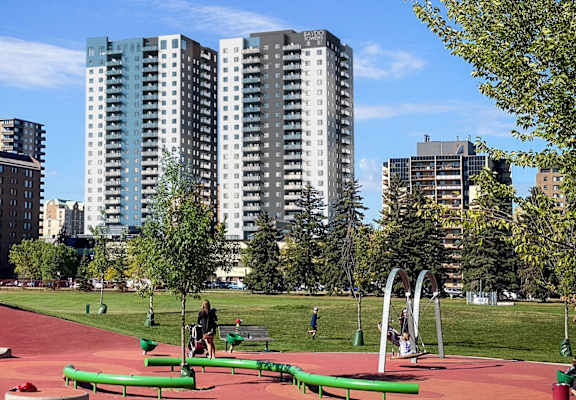 a playground in a park with skyscrapers in the background