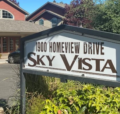 A sign for Sky Vista in front of a building.