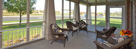 A sunroom with a white ceiling and a view of the street outside.