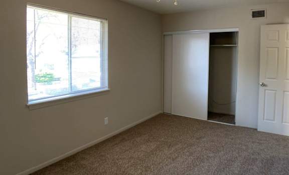 A room with a ceiling fan and carpeted floor.