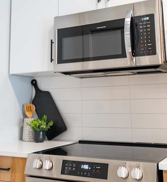 A black microwave oven is mounted above a stove.