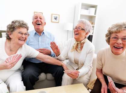 a group of people laughing and playing cards in a living roomat Greenacres, Greenacres, FL, 33467