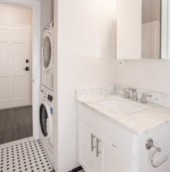 a white bathroom with a washing machine and a sink