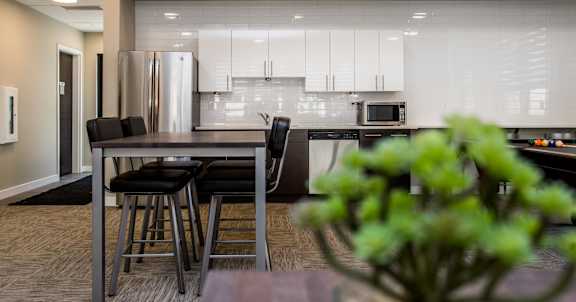 A modern kitchen with a dining table and chairs.