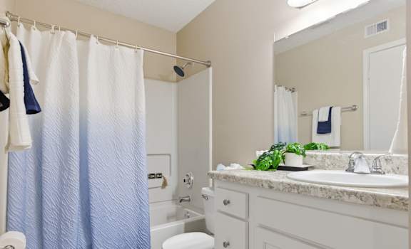 A bathroom with a toilet, sink, and shower.